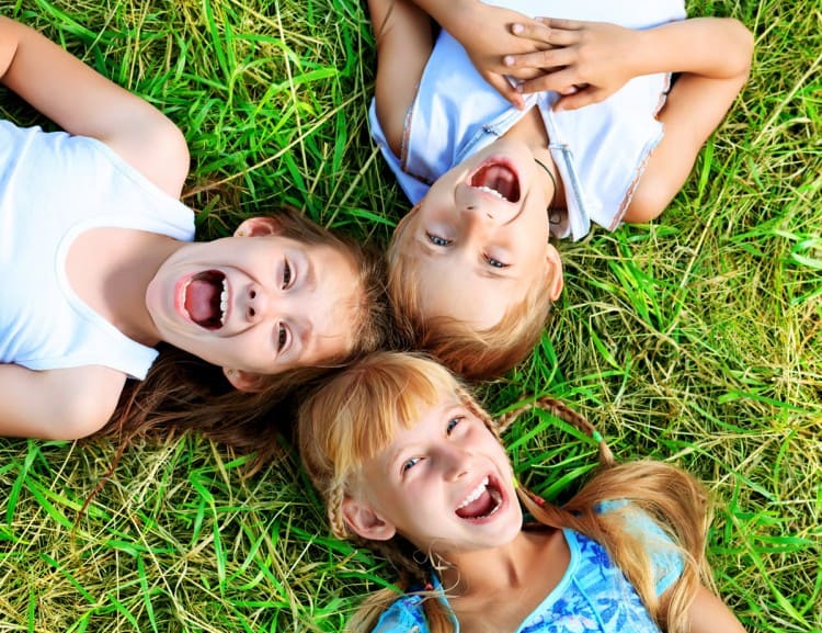 Children lie in the grass and have fun.