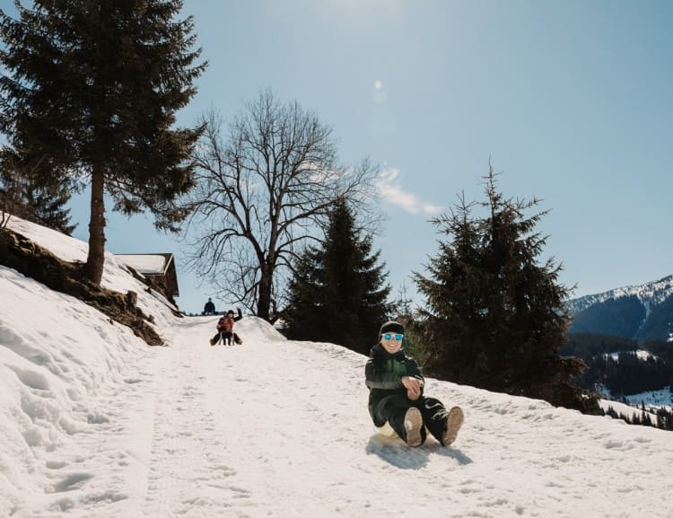 Rodeln auf dem Winterwanderweg hinter dem Stallgebäude © Selina Flasch Photography