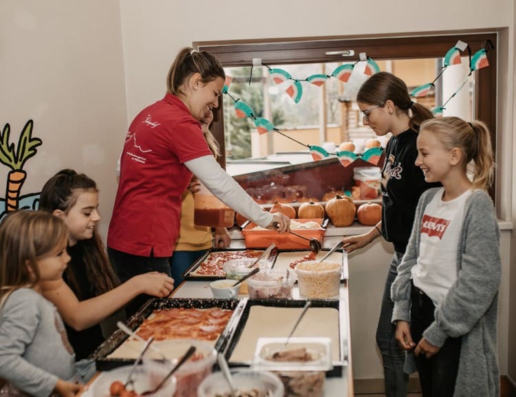 We cook together pizza at the kid's club. © Selina Flasch Photography