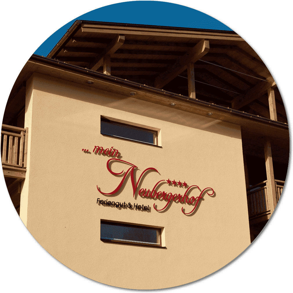 Vorderseite des Hotels im Sommer mit Hauslogo an der Wand